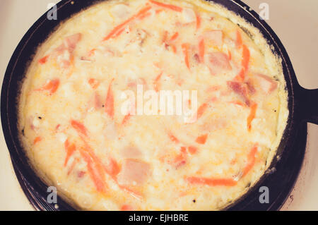 Omelette au plat dans une casserole sur une cuisinière électrique blanc. Filtre de couleurs pastel Banque D'Images