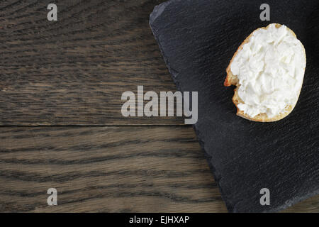 Tranches de baguette croustillante au fromage à la crème sur le bord de l'ardoise Banque D'Images