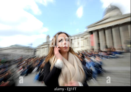 London England UK - Jeune femme sur son téléphone portable dans l'état occupé Trafalgar Square Banque D'Images