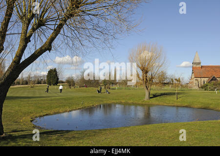 Vue sur l'étang sur le 1er trou au livre vert et une petite église Burnham-on-Crouch Angleterre Essex Golf Club Banque D'Images