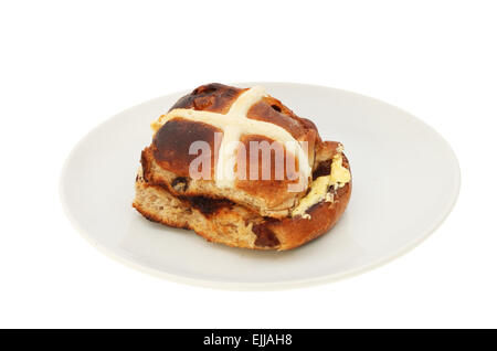 Seul et grillées chaudes beurrées cross bun sur une plaque isolés contre white Banque D'Images