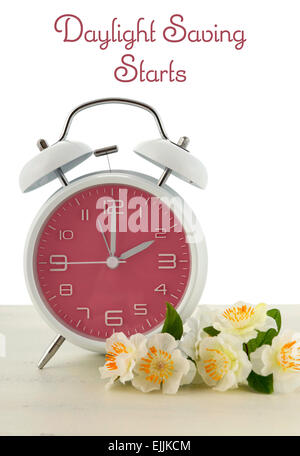 L'heure d'concept avec thème printemps style rétro rose réveil sur fond de bois blanc. Banque D'Images