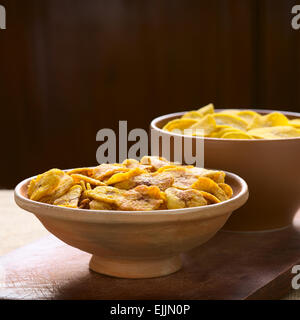 Bols de Sweet (avant) et salé (retour) plantain frites, un snack populaire en Amérique du Sud, photographié avec un éclairage naturel Banque D'Images