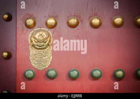 Porte en bois rouge avec golden lion figure à la Cité Interdite, Beijing Banque D'Images