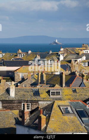 Les toits couverts de lichen à St Ives avec le phare de Godrevy et la baie de St Ives dans la distance, Cornwall, Angleterre, Royaume-Uni. Banque D'Images