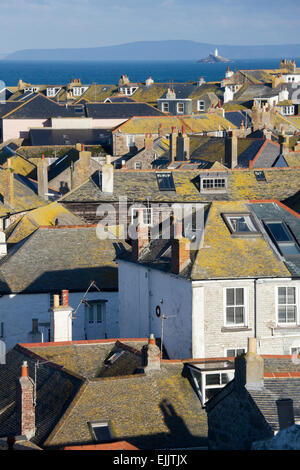 Les toits couverts de lichen à St Ives avec le phare de Godrevy et la baie de St Ives dans la distance, Cornwall, Angleterre, Royaume-Uni. Banque D'Images