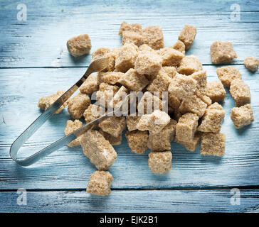 Cubes de sucre de canne sur la table en bois bleu. Banque D'Images