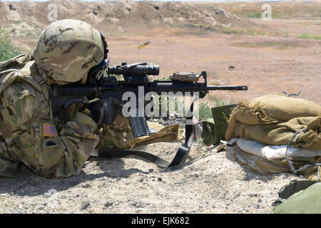 Le sergent de la Garde nationale de l'Armée de l'Oregon. Justin Sheffield, de troupe, 1er Escadron, 82e de cavalerie, d'infanterie 41e Brigade Combat Team, incendies sa carabine M4 tout en portant un masque de protection chimique au cours de qualification d'armes en préparation pour un déploiement à l'Orchard Centre d'instruction au combat, près de Boise, Idaho, 1 juin. Environ 190 soldats de l'escadron va passer neuf mois l'exécution de la sécurité et le soutien des installations militaires en Afghanistan. Le Sgt. Avril 1ère classe Davis, Affaires publiques du Département militaire de l'Oregon Banque D'Images