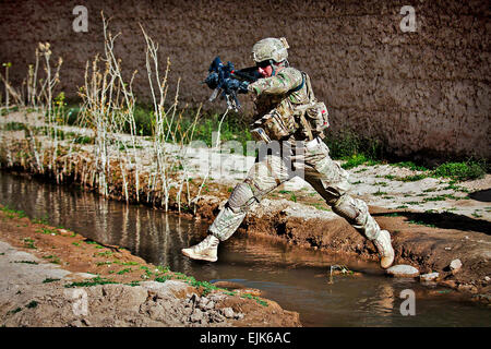 Un parachutiste avec la 82e Division aéroportée, 1ère Brigade Combat Team saute un fossé de l'irrigation sur le bord d'un village 29 mai 2012, la province de Ghazni, Afghanistan. Le peloton du parachutiste effectue plusieurs patrouilles de présence chaque semaine avec des soldats afghans. Le Sgt. Michael J. MacLeod Banque D'Images