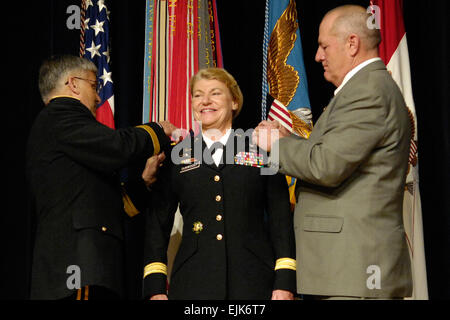 Le lieutenant général de l'armée américaine Ann E. Dunwoody sourit lors de sa promotion au grade de général, où elle a été épinglée par chef d'état-major de l'Armée Le Général George W. Casey, à gauche, et son mari Craig Brotchie durant sa cérémonie au Pentagone le 14 novembre 2008. Dunwoody a fait l'histoire comme la première femme officier 4 étoiles. La Marine américaine Maître de 2e classe Molly A. Burgess Banque D'Images