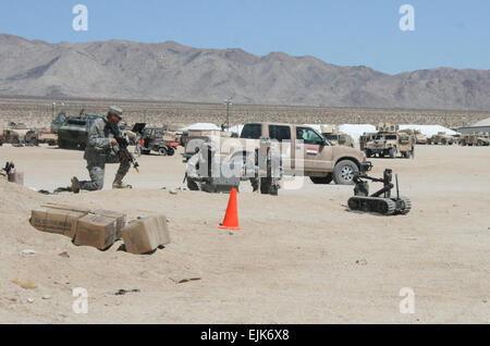 Le Sgt. Bobby Boswell le robot Talon manoeuvres centre d'approcher le Sgt. 1re classe Jason Jenschke pour recevoir des munitions à prendre pour un soldat simulant être coincés par le feu. Les deux soldats sont de la Compagnie C, troupes spéciales, 1er Bataillon Heavy Brigade Combat Team, 1e ArmoredDivision. L'équipe d'ingénieurs avec des robots jusqu'au NTC pour effacer les IED /-news/2009/09/28/27976-ingénieurs-team-up-avec-robot-à-ntc-à-clear-EEI/ Banque D'Images