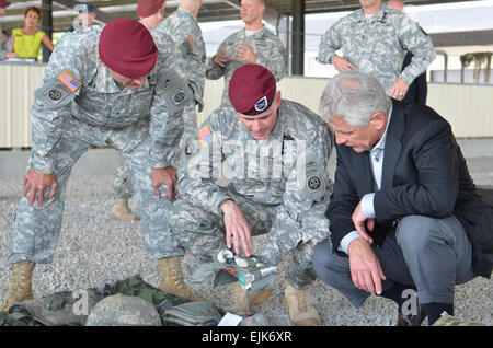 Le brig. Le général Charles Flynn, Commandant général adjoint pour les opérations, la 82e Division aéroportée, et le Colonel Patrick Hynes, commandant, 2e Brigade Combat Team, 325e Airborne Infantry Regiment, 82nd Airborne Division montrent le secrétaire à la défense Chuck Hagel a publié différents articles militaires-soldats aéroportés sont tenus à mettre dans leur Modular Lightweight Load-carrying Equipment MOLLE avant un saut. Hagel à Fort Bragg a été l'un des nombreux autour de grandes installations militaires des États-Unis pour discuter du carbone et d'ancienneté avec les civils, militaires, et leurs familles. Le s.. Reshema Sh Banque D'Images