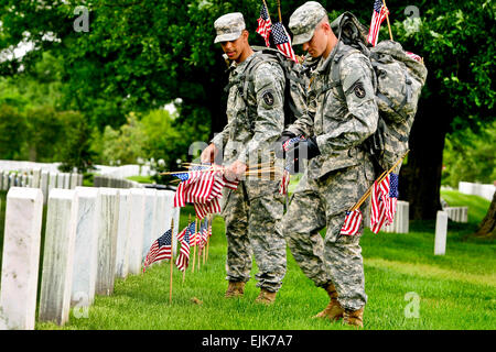 Pvt de l'armée. Aaron Johnson met un petit drapeau américain devant une tombe, lors de l'assemblée annuelle de l'événement "Drapeaux" au cimetière national d'Arlington, à Arlington, Va., 24 mai 2012. Johnson, affecté à la 3e Régiment d'infanterie de l'Armée de "vieille garde," a été l'un de plusieurs soldats de placer des drapeaux place devant plus de 260 000 pierres tombales et environ 7 300 places au cimetière columbarium du. Le Sgt. Jose A. Torres Jr. Banque D'Images