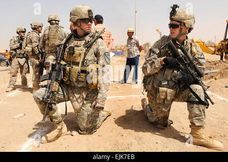 La 1ère Armée américaine, le lieutenant Joshua Vandegriff, gauche, et la FPC. Joshua Cahoon ont une conversation tout en assistant à une cérémonie d'inauguration des travaux pour la liberté, qui est en cours de construction près de la station de Sécurité Commune Ur à Bagdad, l'Iraq, le 23 juin 2009. Vandegriff et Cahoon sont affectés à la Division de cavalerie, 2e Bataillon, 5e régiment de cavalerie, 1 Brigade Combat Team. La CPS. Joshua E. Powell Banque D'Images