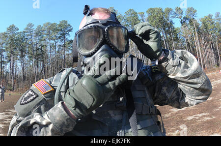 Le Sgt. Bryan Teneyck, représentant l'Installation de la commande gestion, ajuste son masque pendant l'une des armes chimiques, biologiques, radiologiques, nucléaires et explosifs des tâches sur le premier jour de l'édition 2013 du concours meilleur guerrier. Banque D'Images