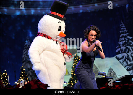 Le sergent-major de l'armée américaine. Martha Krabill chante un medley de Noël pour les enfants à côté de Frosty the Snowman, au cours de l'armée américaine District militaire de Washington Maison de vacances annuel Festival Concert à DAR Constitution Hall de Washington, D.C., 10 décembre 2010. Krabill est une chanteuse soprano et membre du U.S. Army Band Pershing propre. Le s.. Teddy Wade Banque D'Images