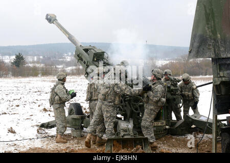 Les soldats de l'Armée américaine affecté à la batterie d'artillerie, Bouledogue, 2e escadron de cavalerie 2CR charger un obusier M777A2 pendant 2CR Exercice de répétition de la manoeuvre du MRE à Grafenwoehr Domaine de formation, l'Allemagne, le 13 février 2013. Spécialiste de l'information visuelle Gertrud Zach/relâché Banque D'Images