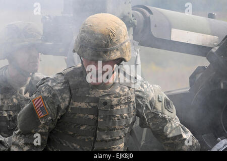 La CPS. Johns Jacob hurle pour un autre 155mm ronde comme le Sgt. Nathan Hughes s'aligne une autre cible au cours d'une cérémonie de la retraite pour l'obusier M198 au Camp Atterbury Centre mixte, Ind., 18 Septembre, 2010. Les deux soldats sont cannon de l'équipage affectés au 2e bataillon du 150e Régiment d'artillerie. Le Sgt. Will Hill Banque D'Images