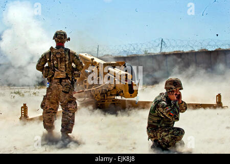 Un soldat de l'Armée américaine à partir de la batterie de gauche B, 5e Bataillon, 25e Régiment d'artillerie, 4e Brigade Combat Team, 10e division de montagne, observe le tir d'un obusier de 122 mm D-30 par des militaires de l'Armée nationale afghane à partir de la 4e Kandak, 3e Brigade, 201e Corps canadien, au cours des exercices de certification à la base d'opérations avancée Tagab, la province de Kapisa, en Afghanistan, le 5 septembre 2013. Batterie B, stationné à la BOA Gamberi dans la province de Laghman, va tout au long de l'Est de l'Afghanistan de conseiller et diriger les soldats de l'artillerie sur la bonne prise en charge des D-30s, une artillerie lourde de fabrication soviétique arme capable d'engager la cible Banque D'Images