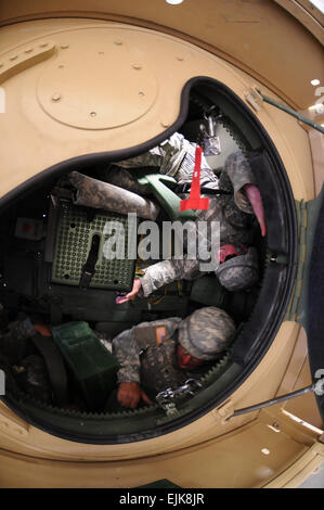 Le Sgt. Shann Snyder de Billings, au Montana, suspendue dans sa ceinture pendant que le Sgt. Glen Naylor travaille lui-même au cours de la formation à l'aide d'Humvee Formateur. Snyder et Naylor, membres de la Garde nationale du Montana 2, détachement du 484e Compagnie de Police militaire sont la formation sur les exercices de combat d'apprendre comment réagir face à la désorientation et la confusion associée à un retournement au cours de la 484e de formation annuel du Co mp à Ft. Harrison, au Montana, le 484e MP Co. est prévu de déployer au printemps de 2010. Banque D'Images