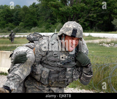 La CPS de l'armée américaine. Courtney Harris porte SPC. Vilayhong Khampraseuth en camp de base lors d'une attaque simulée dans le cadre d'un exercice d'entraînement au Camp Atterbury, Ind., le 4 juin 2007. Les soldats sont de la 1113th Transportation Company, Californie Army National Guard. Le Sgt. Edward I. Siguenza Banque D'Images