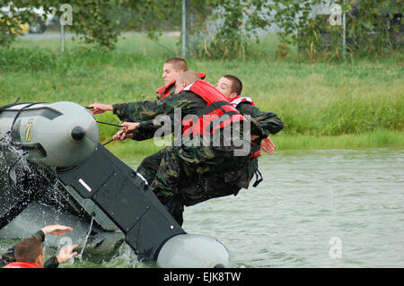 Des soldats de la Garde nationale de l'Indiana participer à la survie de l'eau et l'entraînement opérationnel à un lac à Evansville, Indiana ici, ils tentent de monter à bord de leur canot renversé. Banque D'Images