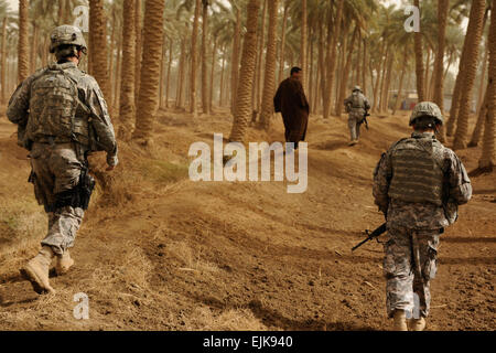 Des soldats américains de l'Administration centrale l'Administration centrale, l'entreprise 2e Bataillon des troupes spéciales, 2e Brigade Combat Team, 4e Division d'infanterie, suivre un homme irakien à une installation de traitement de l'eau dans Shamiyah, l'Iraq, le 11 février 2009. Les soldats de la 2e Brigade Combat Team, 4e Division d'infanterie, a visité plusieurs sites autour de Diwaniya pour évaluer leurs progrès. Banque D'Images