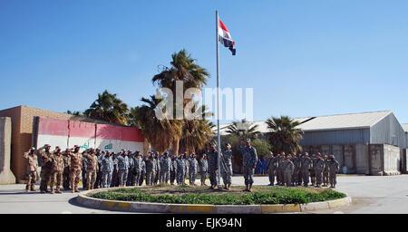 L'armée irakienne, la Police nationale irakienne et des soldats de la Compagnie C, 1er Bataillon, 27e Régiment d'infanterie, qui est joint à la 1e Bataillon, 21e Régiment d'infanterie, "vrilles", 2e Stryker Brigade Combat Team, "Warrior", 25e Division d'infanterie, Division Multinationale ñ Bagdad, regardez le drapeau national irakien tel qu'il est relevé au-dessus du poste de sécurité commune, Salamiyat l'ouest de Bagdad, le 1er janvier. La levée du drapeau symbolise la mise en œuvre de la nouvelle convention de sûreté qui a pris effet le 1er janvier. Banque D'Images