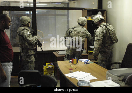 Les soldats de l'Armée américaine affecté à 5e Bataillon, 25e Régiment d'artillerie, 4e Brigade Combat Team, 10e division de montagne, de la Police nationale irakienne à partir de la 3e Bataillon, 1e Brigade Combat Team, 1re Division et les soldats de l'armée iraquienne mener une mission de recherche en armes à feu illégales et dispositif explosif de caches dans Bagdad, Irak, le 15 mars 2008. Le s.. Jason T. Bailey Banque D'Images