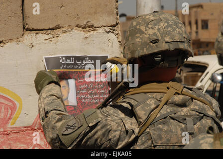 Le sergent de l'armée américaine. Jonathan Pierce raccroche un avis de recherche pour un membre d'al-Qaïda de premier niveau en Saydiyah, Al Rashid, Bagdad, Irak, le 17 mars 2008. Maître de 2e classe Greg Pierot Banque D'Images