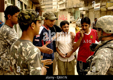 Le sergent de l'armée américaine. Erik Packard, affecté à la Compagnie Alpha, 13e Bataillon d'opérations psychologiques, parle aux gens de l'Iraq à Bagdad, l'Iraq, le 27 mars 2008. Le s.. Jason T. Bailey Banque D'Images