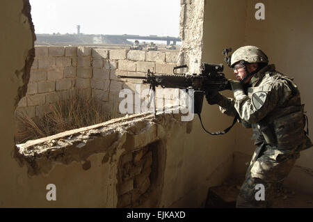 La CPS de l'armée américaine. Brett Bell, un spécialiste des feux d'appui affecté à la Compagnie Echo, 2e Bataillon, 5e régiment de cavalerie, 1re Division de cavalerie, les recherches de contacts pendant une opération de bouclage et de ratissage dans l'ouest de Bagdad, l'Iraq, le 23 février 2007. Maître de 2e classe Kitt Amaritnant, Marine américaine. Publié Banque D'Images