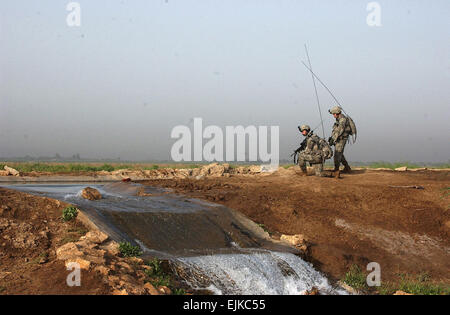 Les soldats de l'armée américaine s'arrêter pour écouter une transmission radio au cours d'une opération conjointe avec les forces irakiennes dans la région de l'Irak Mahmudiyah, 2 mai 2007. Les soldats sont des Alpha Batterie, 2e Bataillon, 15e Régiment d'artillerie, 10e Division de Montagne Light Infantry. Le Sgt. Jacob H. Smith, de l'armée américaine. Banque D'Images