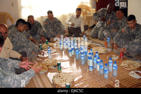 L'Armée américaine du 2e Bataillon, 35e Régiment d'infanterie, 3e Brigade Combat Team, 25e Division d'infanterie de l'Armée de l'air et des aviateurs de la Caméra de combat mixte - Iraq partager un repas organisé par un leader local dans le village de Hasary Gawra dans l'Altun Kapri district de Kirkouk, en Irak, le 9 mai 2007. Le s.. Isaac B. Scruggs Banque D'Images