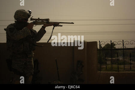 Un sniper de la Compagnie Alpha, 2e Bataillon, 3e Régiment d'infanterie, recherche les tireurs ennemis d'un toit à Rashid, l'Iraq, le 2 juin 2007. Le Sgt. Tierney Nowland Banque D'Images