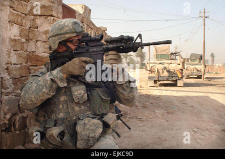 Circuit de l'armée américaine. Andrew Reinke numérise son secteur pour les tireurs d'élite pendant les opérations avec les soldats de l'armée irakienne dans le domaine Khamaliyah de Bagdad, l'Iraq, le 27 juin 2007. Le s.. Bronco Suzuki Banque D'Images