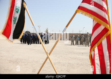 Les soldats du 1er Bataillon, 38e Régiment d'infanterie, 4e brigade Stryker, 2e Division d'infanterie et de police irakienne salue le drapeau américain lors d'une cérémonie au Centre commun de coordination Abou Ghraib à Bagdad, l'Iraq, le 20 avril. La cérémonie a eu lieu pour établir le transfert de JCC Abu Ghraib à partir d'une opération conjointe de contrôle de police irakienne. Banque D'Images