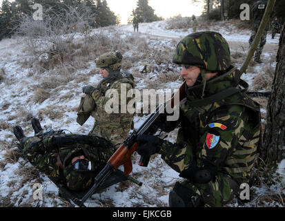 L'armée américaine et de soldats roumains de l'Équipe de liaison et de mentorat opérationnel 7 ELMO, tirer la sécurité tout en un camarade offre une aide médicale au cours d'un itinéraire d'évacuation médicale et de tenir compte de l'entraînement à la préparation multinationales conjointes en JMRC Centre Hohenfels, Allemagne Jan.16, 2012. 10 OMLT prennent part à 17 jours de formation conçu pour les préparer pour des missions à l'appui de l'Afghanistan's long - sécurité à long terme. L'JMRC de l'armée américaine est le seul centre de formation à l'extérieur des États-Unis et de l'avant-déployées en Europe et aux États-Unis et les trains régulièrement des forces multinationales. La CPS. Stephe Banque D'Images