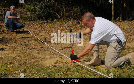 Le sergent de l'US Air Force. Christopher Gremling livres dans une grille de jeu tandis que le sergent de l'armée américaine. William Fouse tient le ruban de mesure en place au cours de l'excavation d'un écrasement dans le Boualapha Province du Laos, le 13 janvier 2008. Les deux hommes font partie d'un prisonnier de guerre interarmées/Missing in action commande Comptabilité équipe déployée hors de Hickam Air Force Base, Texas, au Laos pour 30 jours pour tenter de récupérer les restes de service américain ont perdu lors de la guerre du Vietnam. Le s.. Akeba Parution du Saint-Laurent Banque D'Images