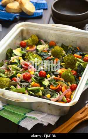Les légumes cuits (courgettes, l'oignon, tomate cerise, brocoli, carottes, maïs doux, haricot vert, blettes) assaisonné de thym dans le moule Banque D'Images