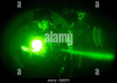 Les soldats des Forces spéciales américaines le site d'examen des données pendant la conduite d'une opération dans le district de Panjawi, province de Kandahar, le 10 juillet 2010. Au cours de l'opération conjointe entre les États-Unis, l'Afghanistan et les forces de la Coalition, plus de 500 livres d'explosif a été retrouvé à côté d'autres dispositifs explosifs de matériaux. Tous les documents, y compris une motocyclette montés avec des explosifs, a été détruit par la force combinée. Le Sgt. David Russell Banque D'Images