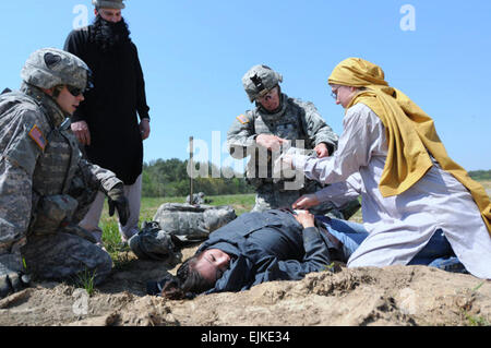 Une grève medic et une grève interprète avec la société D, 2e Bataillon, 502e Régiment d'infanterie, 2e Brigade Combat Team, 101st Airborne Division Air Assault, aider une femme blessés national local lorsqu'elle a été blessé par le feu de l'ennemi tandis que dans un village afghan lors d'une mission tactique à l'appel, le 15 avril. Un appel tactique est une approche non létales puissance détentrice des cibles de grande valeur sans créer des dommages collatéraux comme la Brigade grève renforce sa politique de contre-insurrection. Blitz : Grève www.dvidshub.net/ ?script =news/news show.php&amp;id =48485 hors appel tactique Banque D'Images