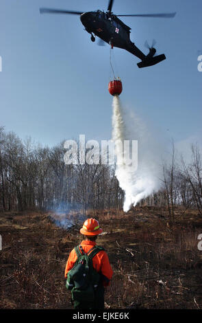 Mike Eilers guides un UH-60A Black Hawk de l'équipage de la Garde nationale du Minnesota qu'il déverse l'eau d'un seau Bambi au cours de formation incendie au Camp Ripley, Minnesota, le 20 avril 2007. Eilers est avec la division forestière de la Minnesota Department of Natural Resources. Le s.. Kenneth R. Toole, U.S. Air Force. Banque D'Images