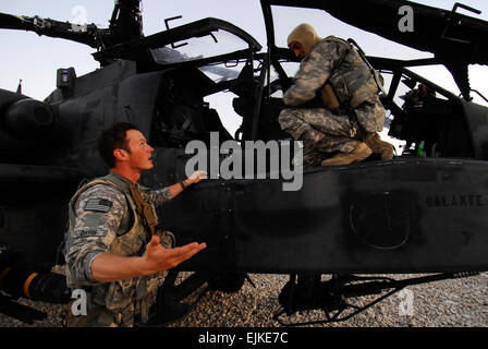 L'Adjudant-chef de l'armée américaine 2 Mark Davis à gauche et l'Adjudant-chef Mike 3 Croslin discuter de leur dernière mission après l'atterrissage d'un hélicoptère Apache AH-64 de la société B, 1er Bataillon, 4e Régiment d'aviation, Bataillon de Reconnaissance, d'attaque à Kunduz, Afghanistan, le 24 juillet 2010. L'Apache a atterri à faire le plein après une fusillade avec des insurgés. Maître de 2e classe Walter M. Wayman, Marine américaine. Banque D'Images