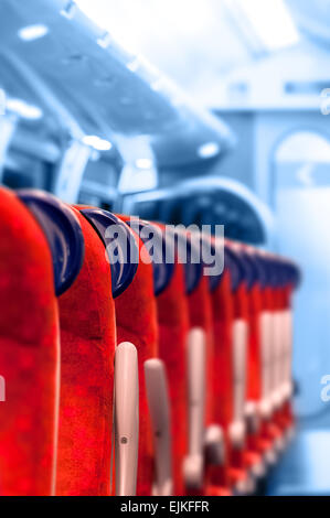 Train vide sièges dans une rangée - fond bleu clair Banque D'Images