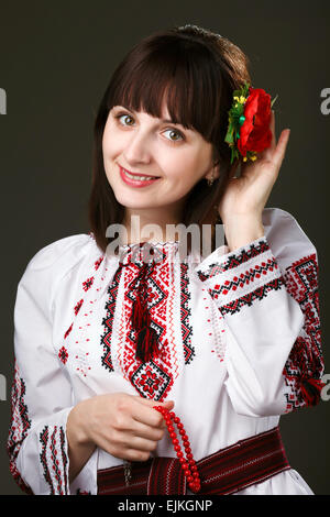 Belle femme dans une chemise brodée avec des fleurs dans les cheveux Banque D'Images