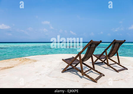 Deux chaises longues face à la mer sur une mer de l'aine de la défense à l'île de Makunudu dans les Maldives Banque D'Images