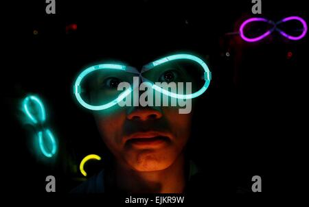 Sunway, Malaisie. Mar 28, 2015. Un homme portant la lueur dans l'obscurité stick formé pour une lunettes de soleil au cours de l' "heure de la terre en fête à l'extérieur de l'hôtel Sunway Kuala Lumpur, Malaisie. L'heure de la terre est un mouvement mondial de la planète organisé par le World Wide Fund for Nature (WWF). L'événement a lieu chaque année dans le monde d'encourager les individus, les communautés, les ménages et les entreprises à éteindre leurs lumières non essentielles pendant une heure, à partir de 8:30 à 9:30 dans la soirée. Rasid Crédit : Mohd/Pacific Press/Alamy Live News Banque D'Images