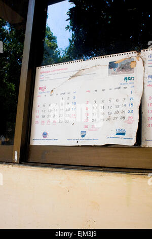 4 ans pages du calendrier sont attachés à une fenêtre de classe à l'Université de l'Agriculture dans la province de Kampong Cham, au Cambodge. Banque D'Images