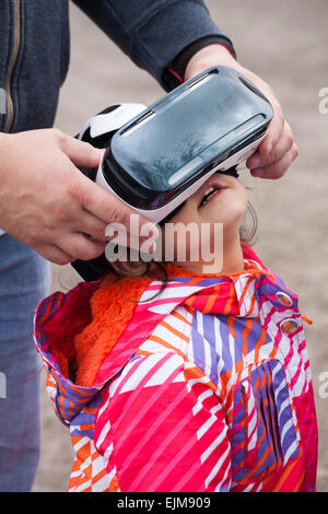 Aider la jeune fille à regarder un film sur le casque de réalité virtuelle Samsung Gear VR - Royaume-Uni Banque D'Images